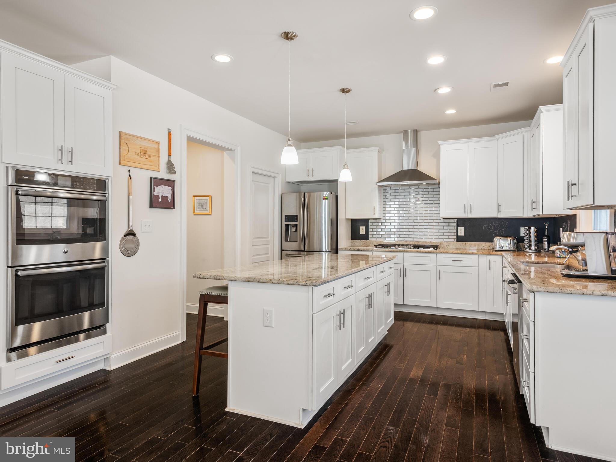 1718 Bethel Road Garnet Valley, PA 19060 - Photo 26 of 58 a kitchen with stainless steel appliances granite countertop a stove top oven a sink dishwasher and a refrigerator with wooden floor