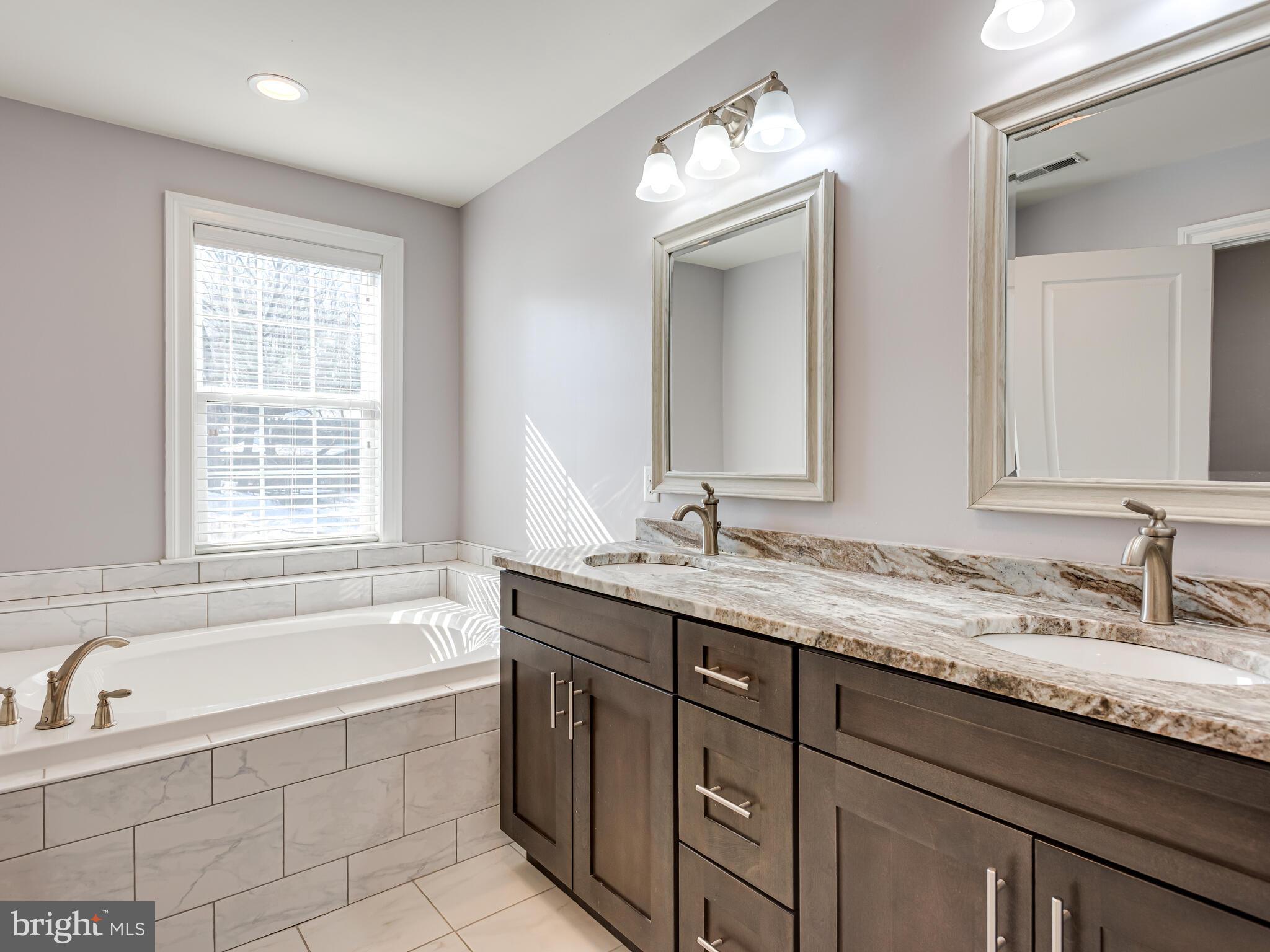 1718 Bethel Road Garnet Valley, PA 19060 - Photo 37 of 58 a bathroom with a granite countertop bathtub a double vanity sink and mirror