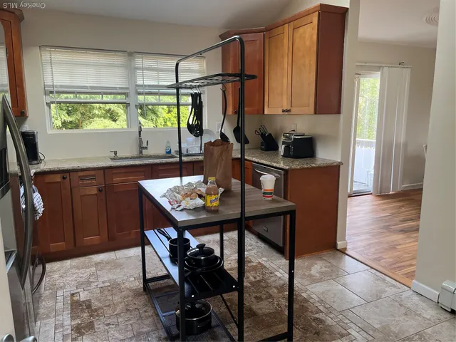 a kitchen with stainless steel appliances granite countertop a sink and a refrigerator