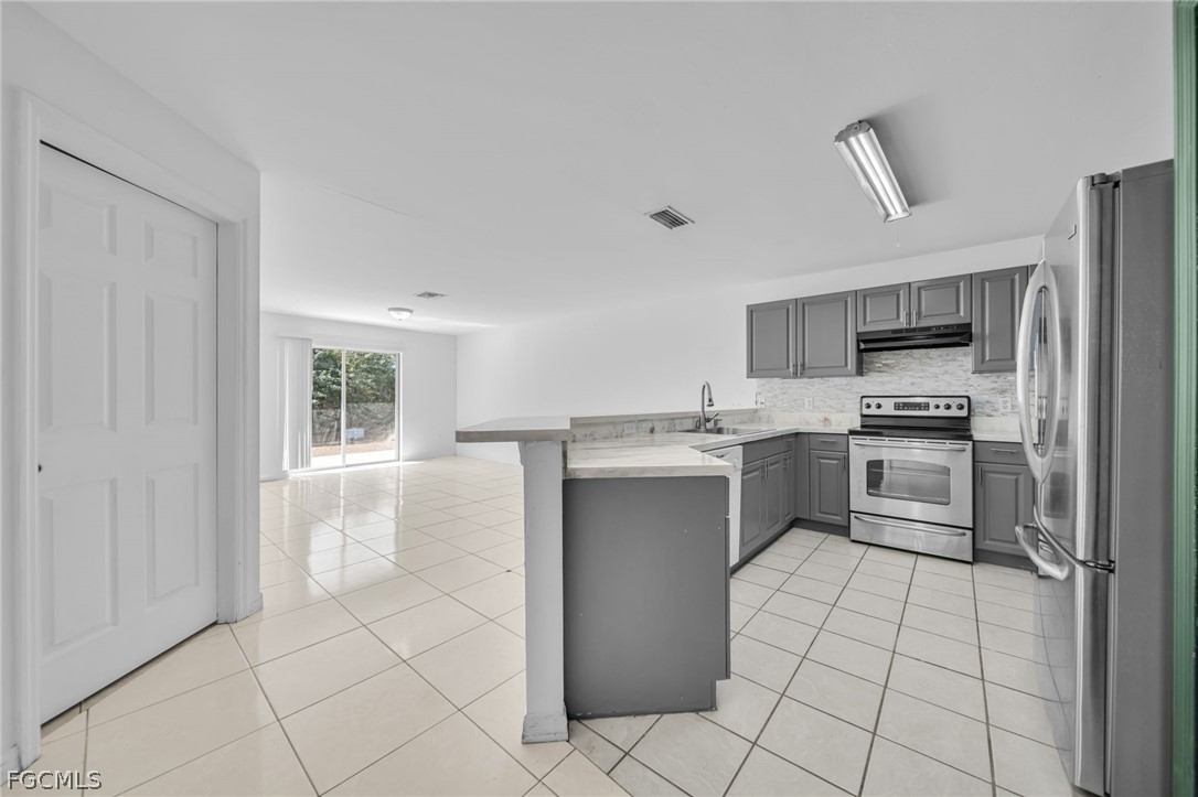 4549 22nd Street Southwest Lehigh Acres, FL 33973 - Photo 11 of 27 a kitchen with a refrigerator sink and cabinets