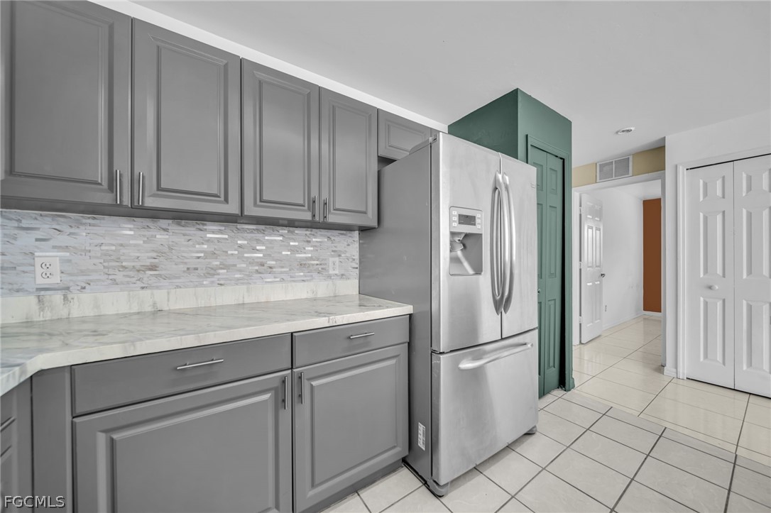 4549 22nd Street Southwest Lehigh Acres, FL 33973 - Photo 13 of 27 a kitchen with stainless steel appliances granite countertop a refrigerator and a sink