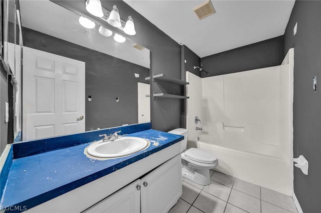 4549 22nd Street Southwest Lehigh Acres, FL 33973 - Photo 20 of 27 a bathroom with a sink a toilet a mirror and shower