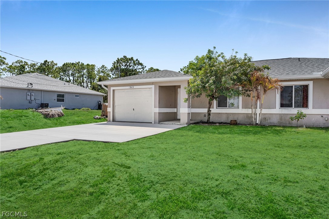 4549 22nd Street Southwest Lehigh Acres, FL 33973 - Photo 3 of 27 a view of a house with a yard and potted plants