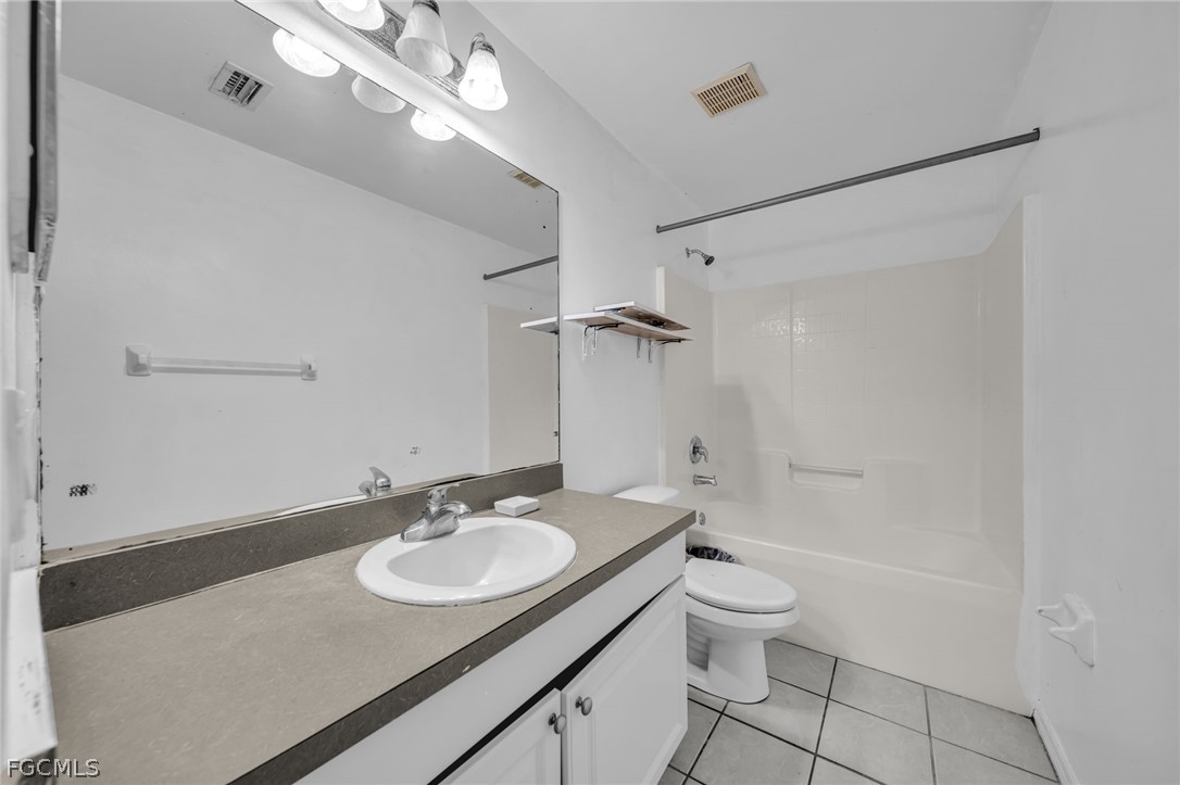 4549 22nd Street Southwest Lehigh Acres, FL 33973 - Photo 7 of 27 a bathroom with a granite countertop sink a toilet a mirror and shower