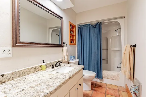 a bathroom with a granite countertop sink toilet and shower
