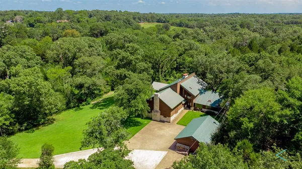 an aerial view of a house with swimming pool and garden