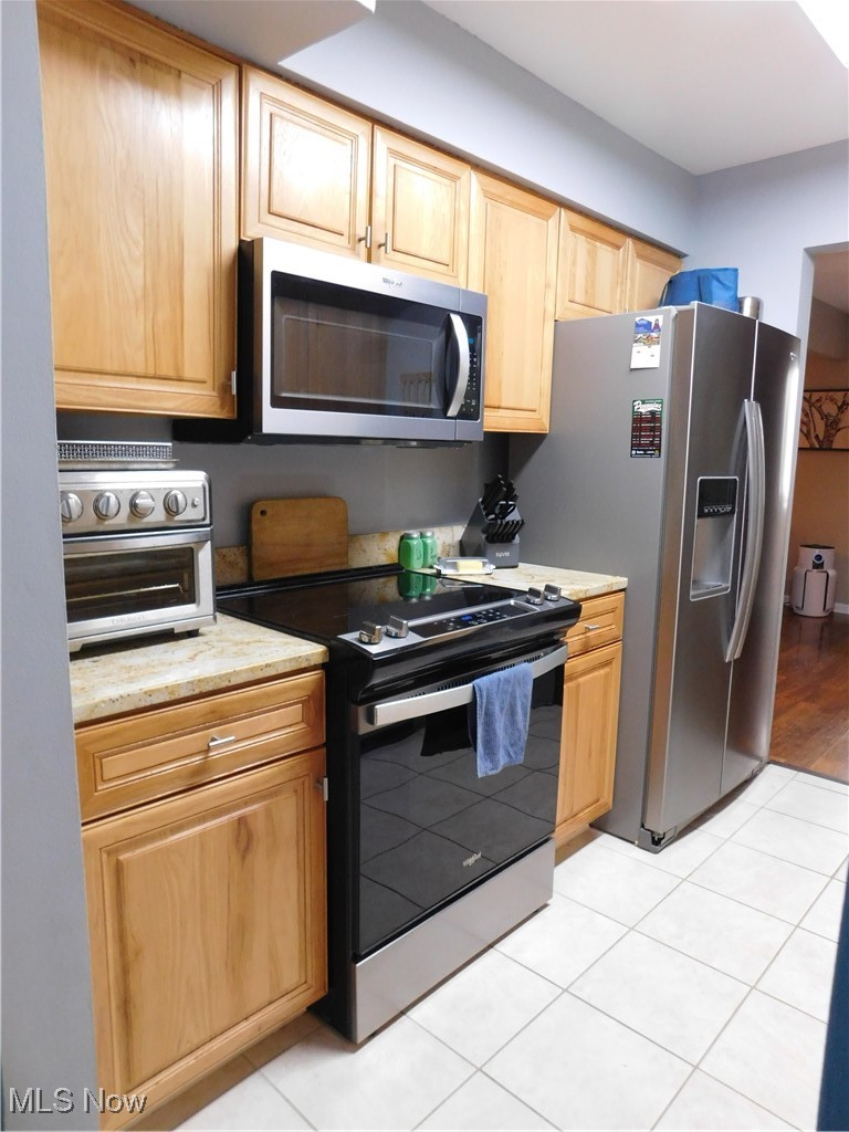 987 Hampton Ridge Drive Akron, OH 44313 - Photo 18 of 49 Kitchen with stainless steel appliances, light tile patterned floors, and light granite countertops