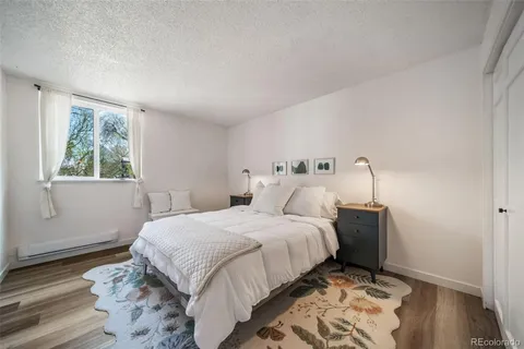 a bedroom with a bed and a refrigerator