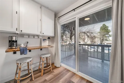 a kitchen with a sink and a stove with white cabinets