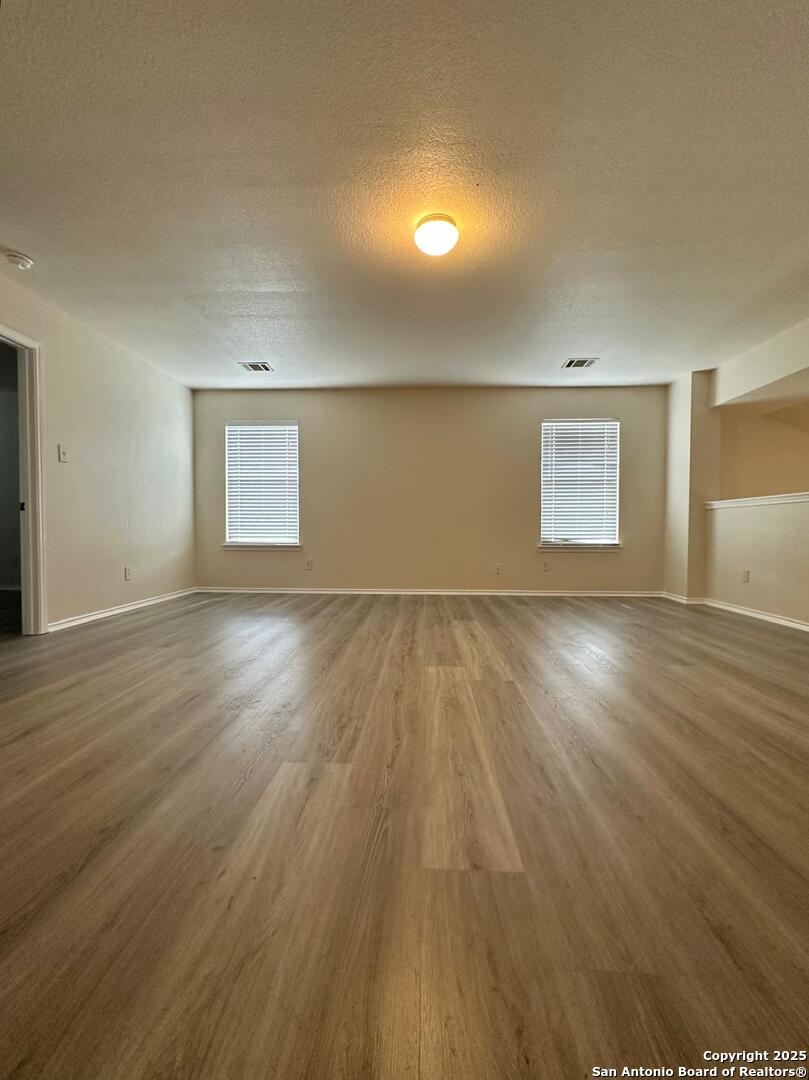 9414 Ingleton San Antonio, TX 78245 - Photo 11 of 17 an empty room with wooden floor and windows