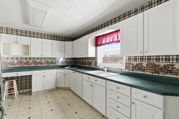 a kitchen with granite countertop white cabinets and stainless steel appliances