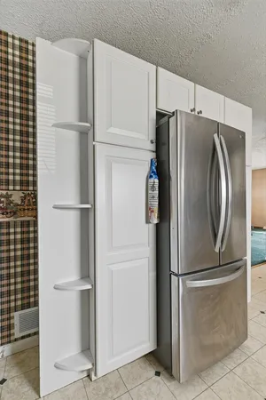 an empty room with a chandelier fan and closet area