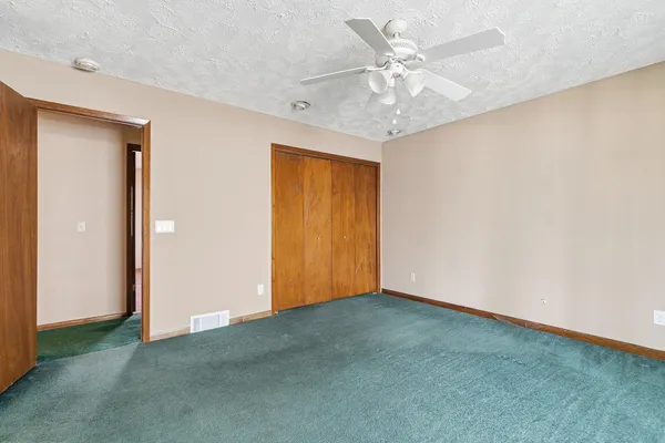 an empty room with chandelier fan