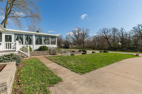 a front view of a house with a yard and potted plants