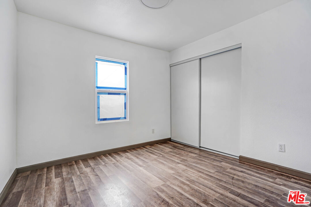 7594 Peters Street Riverside, CA 92504 - Photo 12 of 16 a view of an empty room with wooden floor and a window