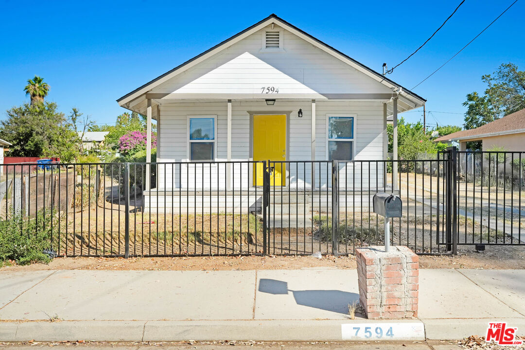 7594 Peters Street Riverside, CA 92504 - Photo 2 of 16 a view of a house with a small yard and wooden fence