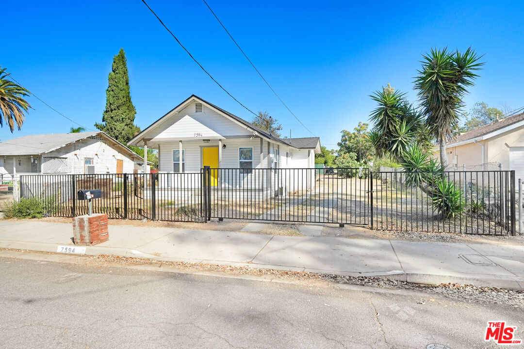7594 Peters Street Riverside, CA 92504 - Photo 5 of 16 a front view of a house with a garden and yard