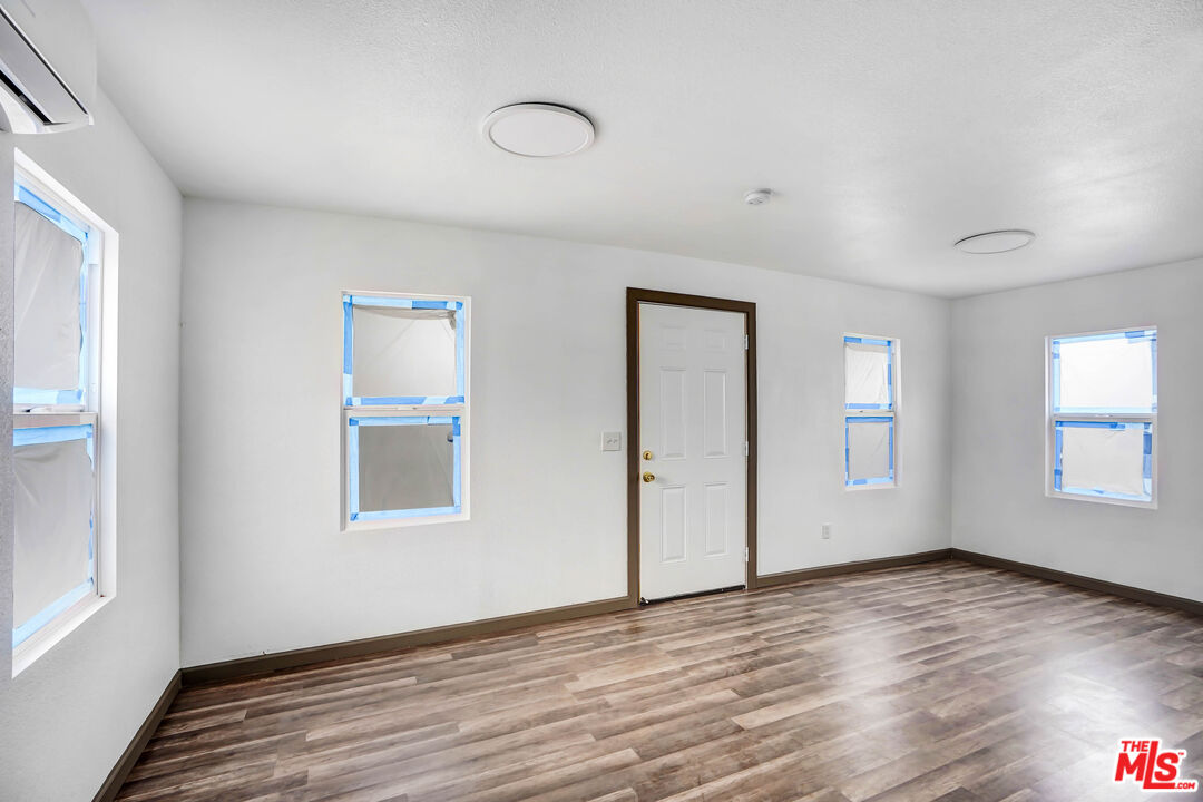 7594 Peters Street Riverside, CA 92504 - Photo 8 of 16 an empty room with wooden floor and windows
