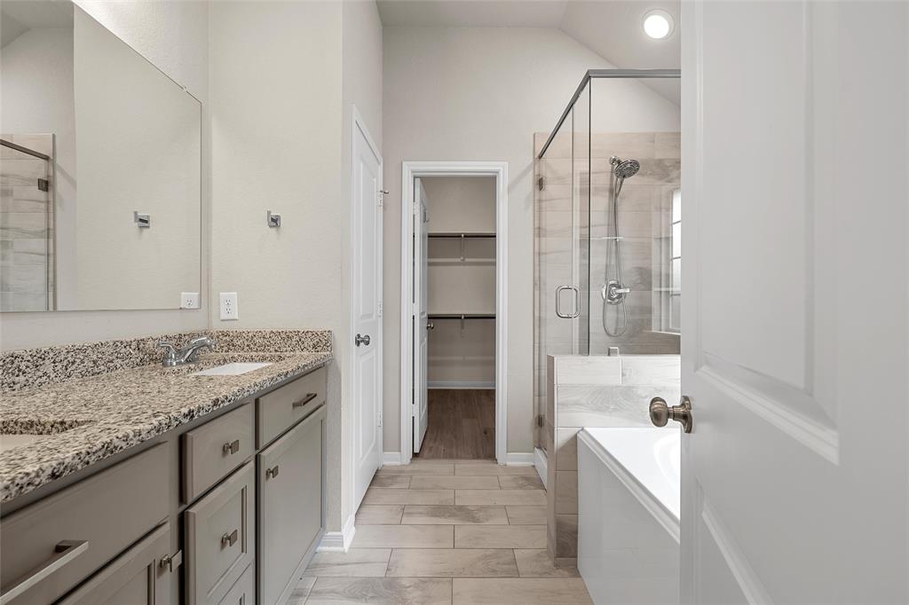 3224 Dottavio Road Lorena, TX 76655 - Photo 22 of 31 Bathroom featuring a double vanity with stone countertops, a full-width mirror, a walk-in shower with glass enclosure, a built-in bathtub, and wood-look tile flooring