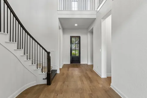a view of a hallway with wooden floor and entryway