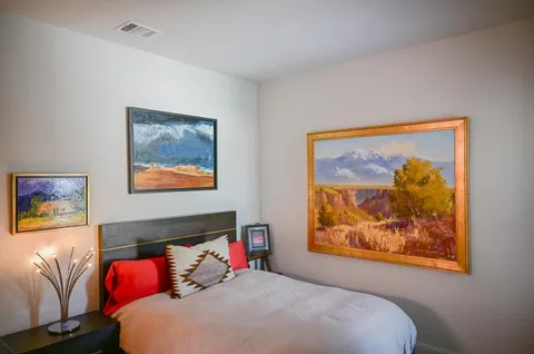a bedroom with a bed and a painting on the wall