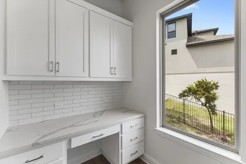 a kitchen with a white cabinets and a potted plant