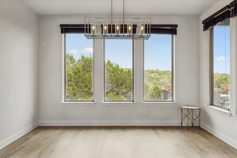 en empty room with windows and ceiling fan