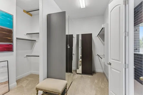 a view of an empty room with closet and a window