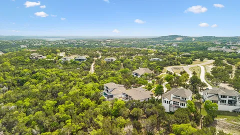 an aerial view of residential houses with outdoor space and trees