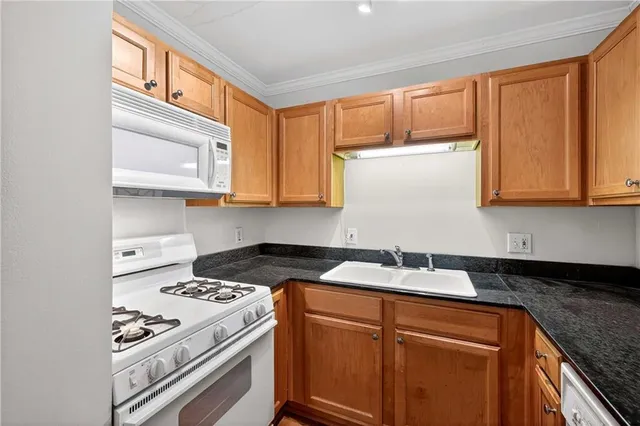 a kitchen with stainless steel appliances granite countertop a sink stove top oven and cabinets