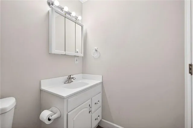 a bathroom with a sink vanity and a toilet