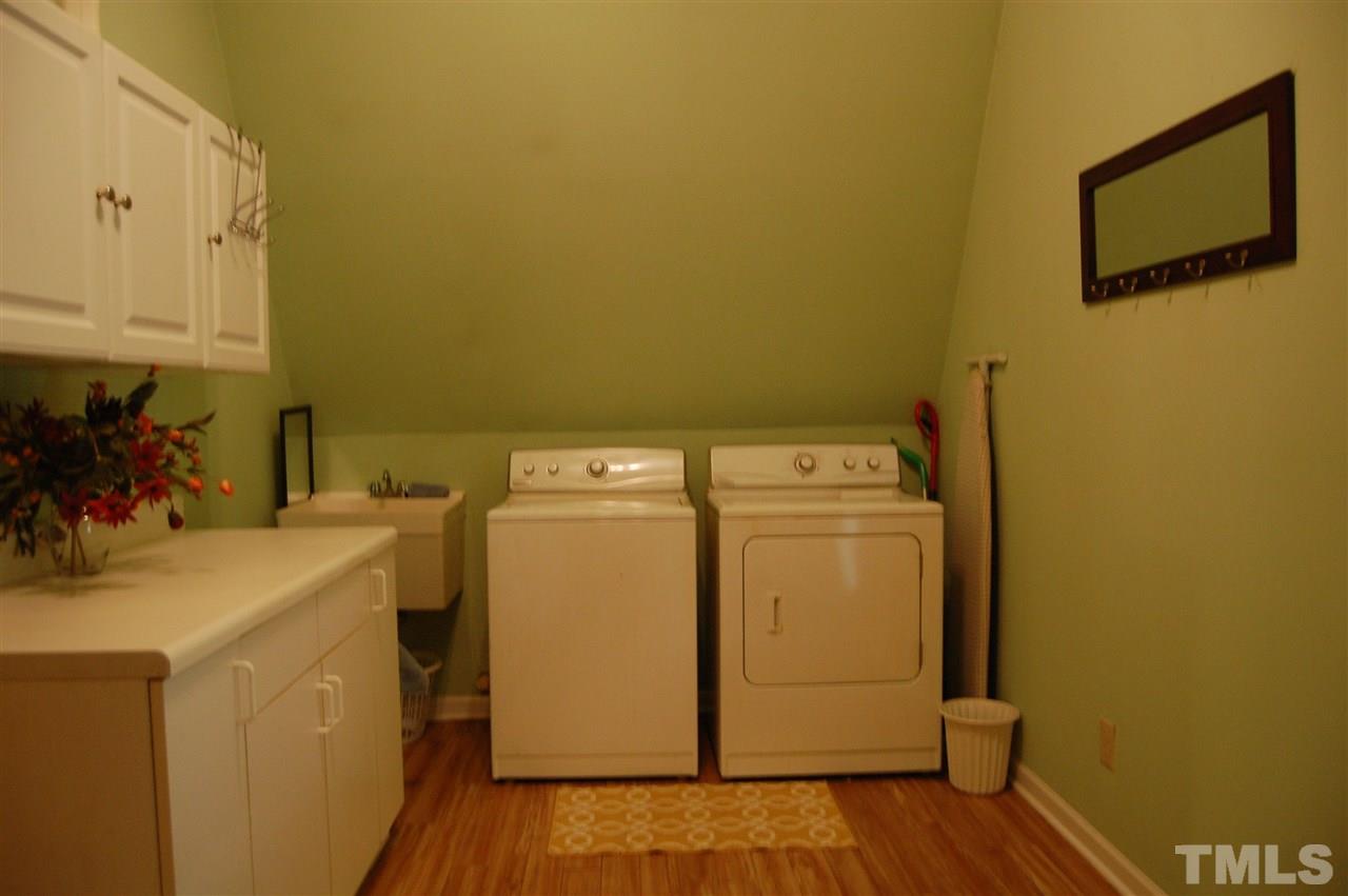 1121 Batchelor Road Apex, NC 27523 - Photo 17 of 30 Utility Room (15.2x8.3) w/Cathedral ceiling, vinyl flooring, long counter top w/cabinets above, heavy duty sink in corner & washer & dryer convey!