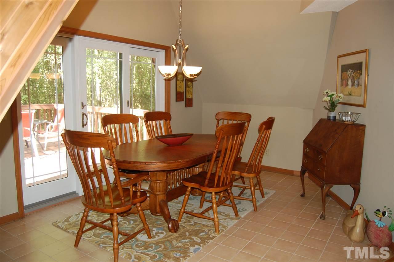 1121 Batchelor Road Apex, NC 27523 - Photo 7 of 30 Dining Room w/ tile floor, sliding glass door to large deck (18.2x19) w/electric awning, chandelier & Cathedral ceiling!