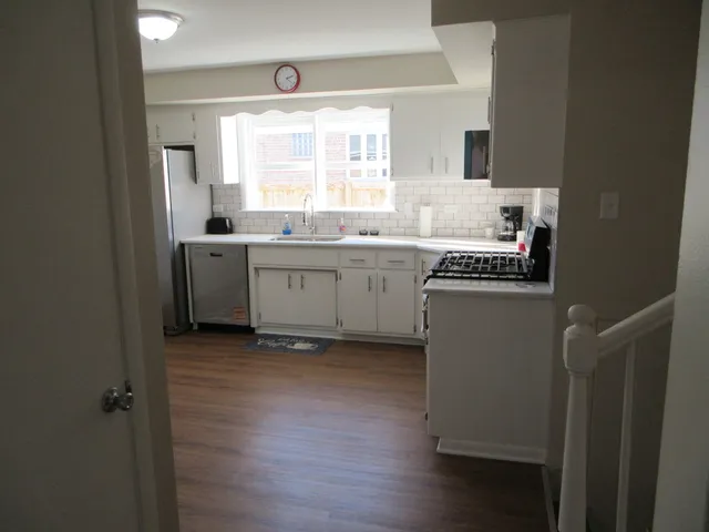 a kitchen with sink cabinets and wooden floor