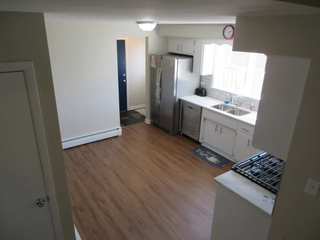 a kitchen with granite countertop a sink stove and refrigerator