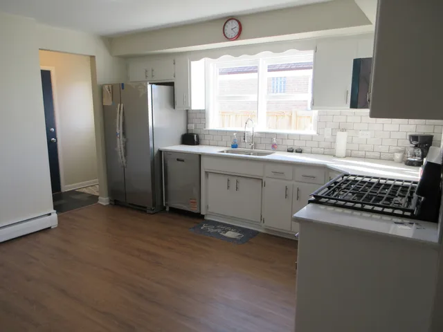 a kitchen with granite countertop a sink stove and refrigerator