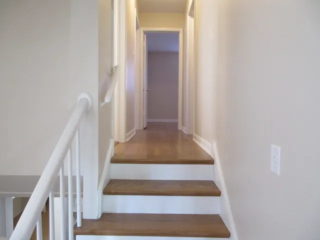 a view of staircase with white walls and white door
