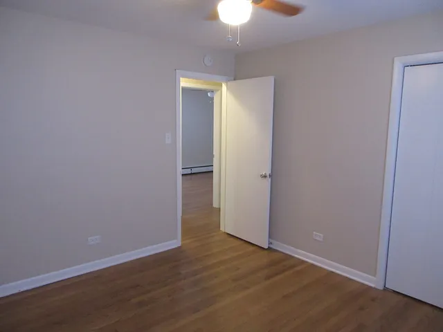an empty room with wooden floor and closet