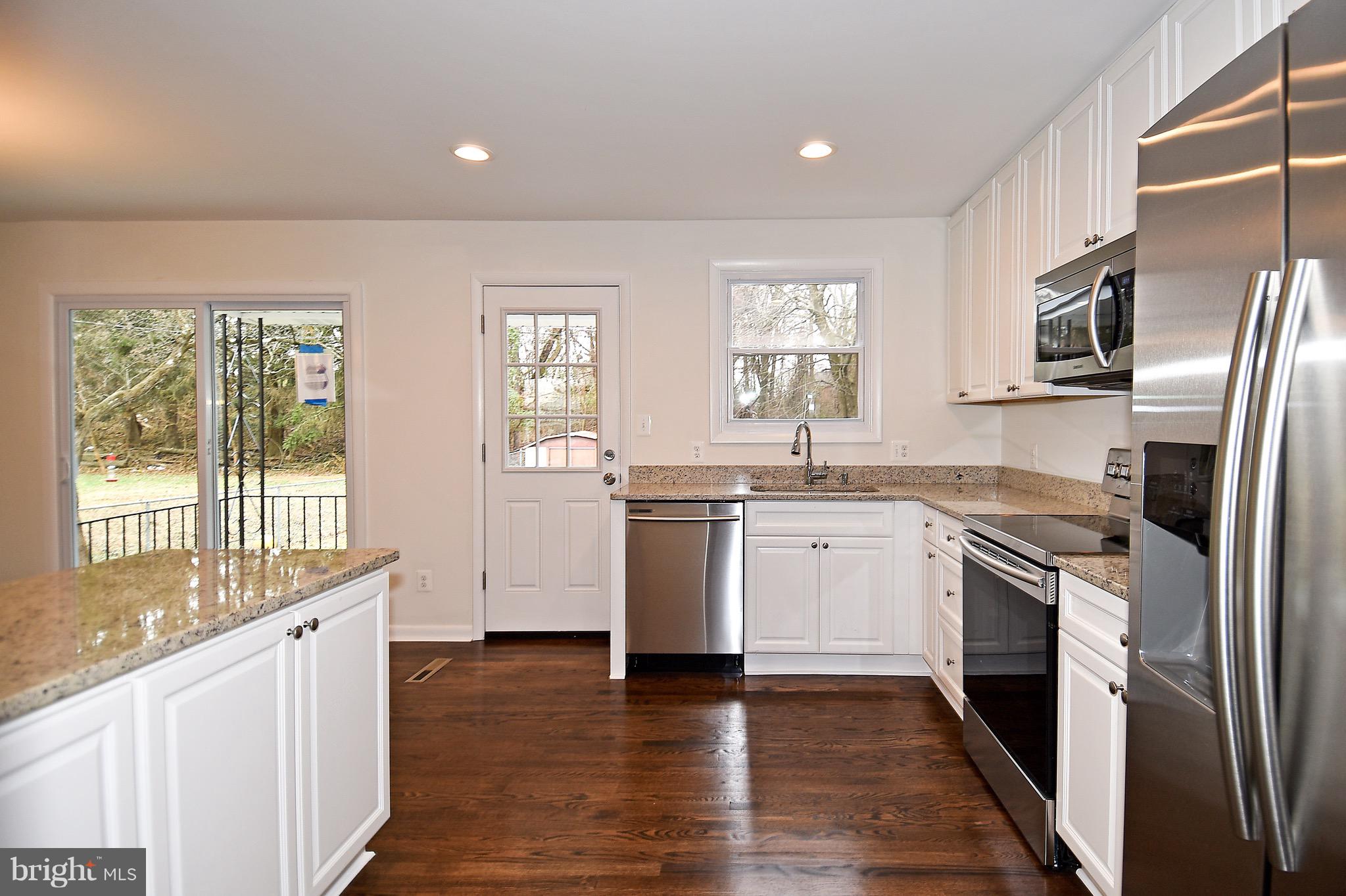 8609 Woodspring Road Randallstown, MD 21133 - Photo 13 of 43 a kitchen with granite countertop white cabinets and stainless steel appliances