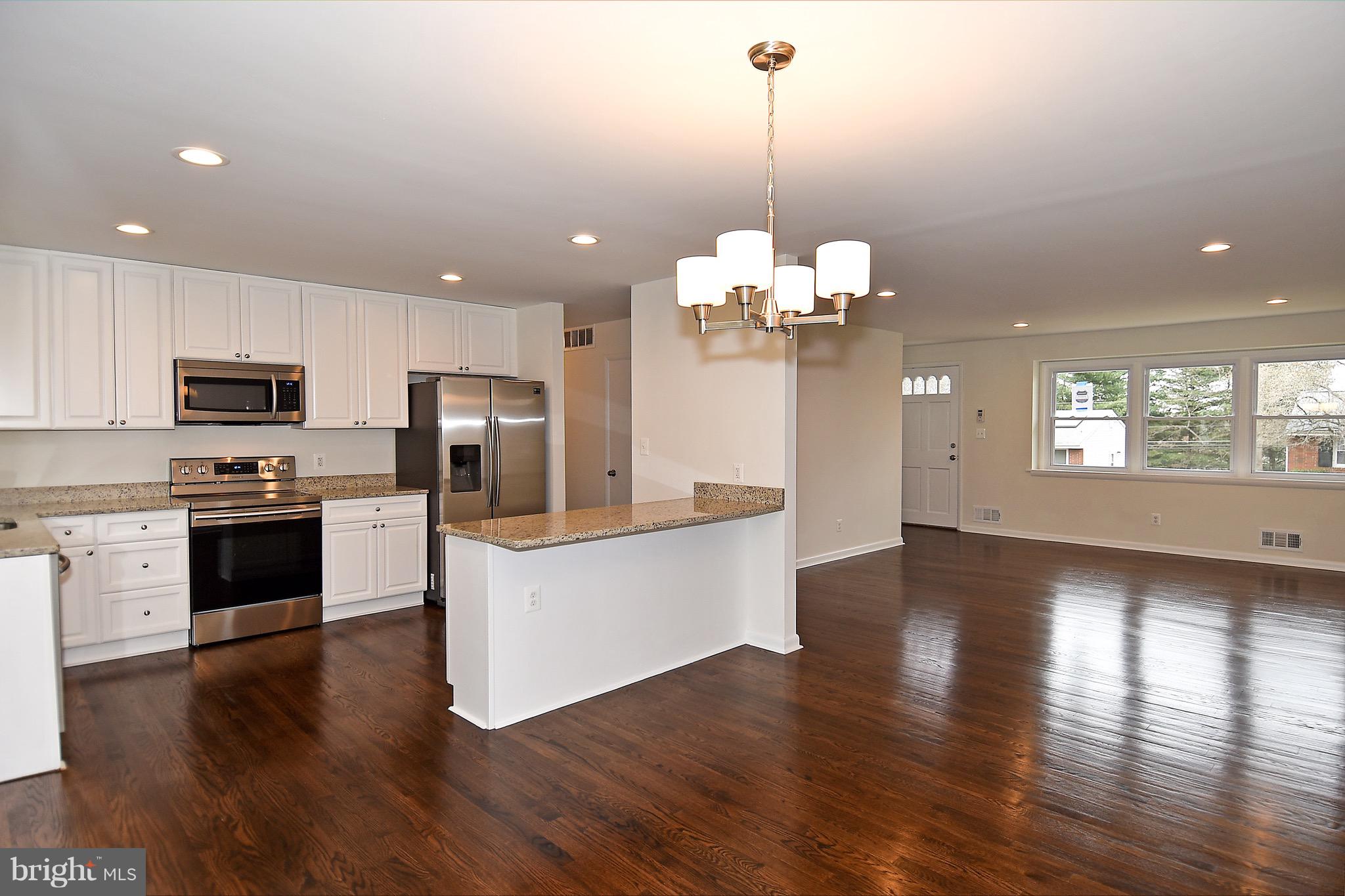 8609 Woodspring Road Randallstown, MD 21133 - Photo 14 of 43 a view of a kitchen with sink microwave and stove top oven