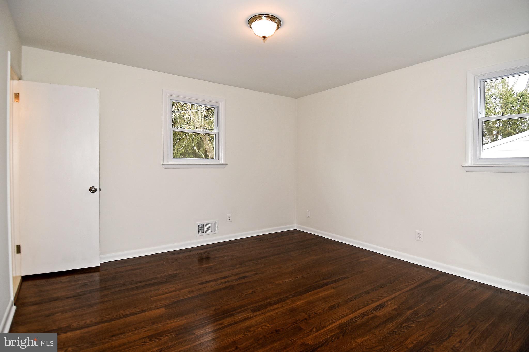 8609 Woodspring Road Randallstown, MD 21133 - Photo 18 of 43 a view of an empty room with wooden floor and a window