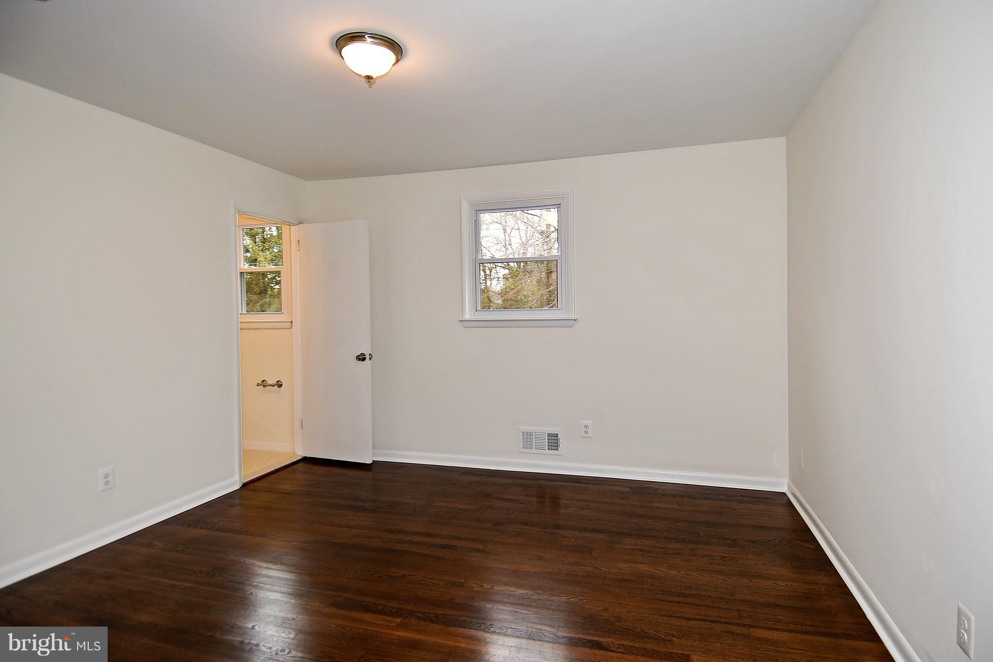 8609 Woodspring Road Randallstown, MD 21133 - Photo 19 of 43 an empty room with wooden floor and windows