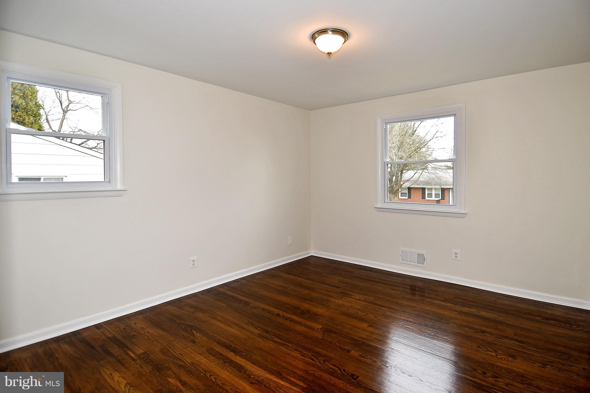 8609 Woodspring Road Randallstown, MD 21133 - Photo 23 of 43 an empty room with wooden floor and windows