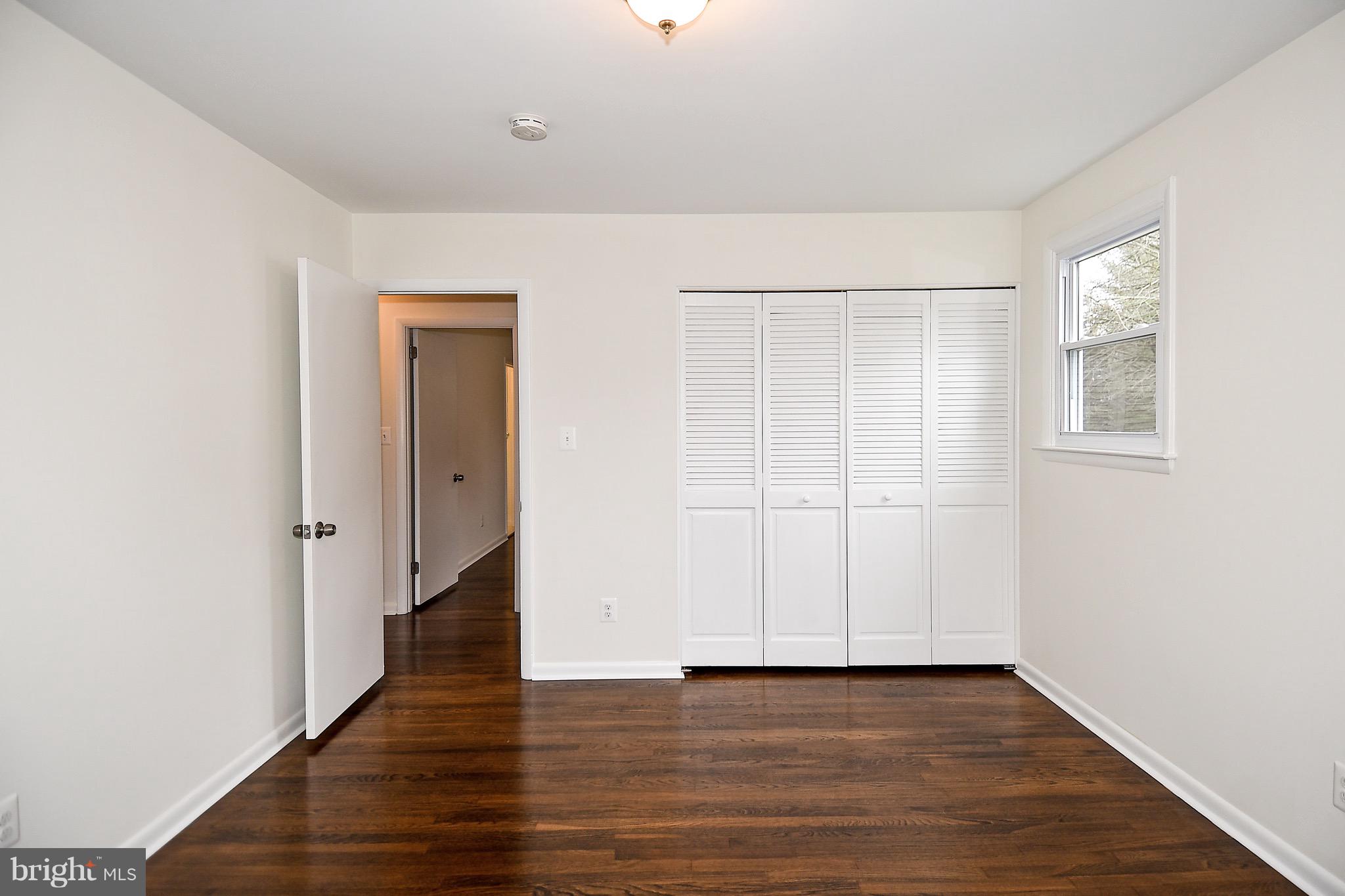 8609 Woodspring Road Randallstown, MD 21133 - Photo 24 of 43 a view of an empty room with wooden floor and a window