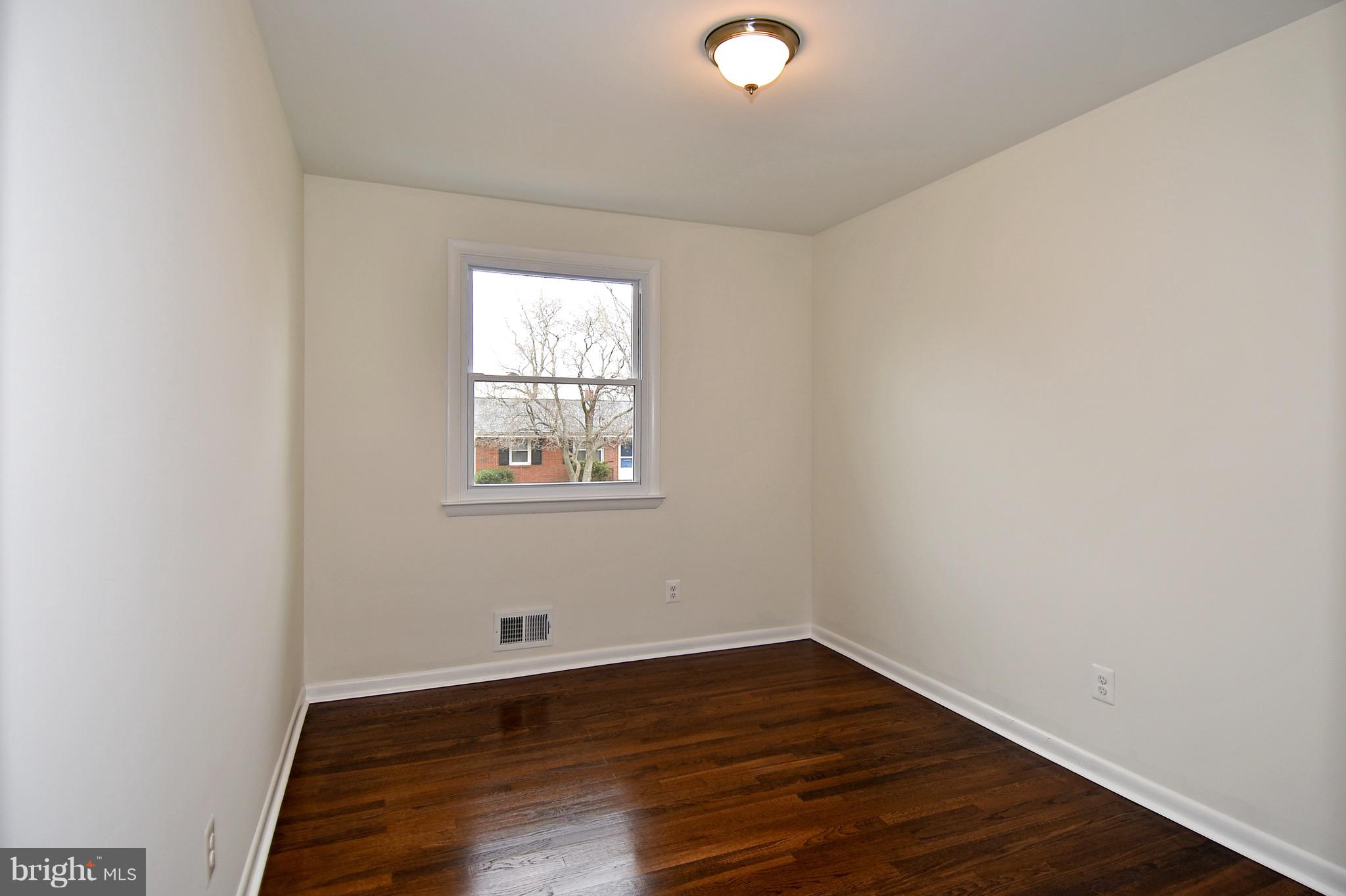 8609 Woodspring Road Randallstown, MD 21133 - Photo 25 of 43 a view of an empty room with wooden floor and a window