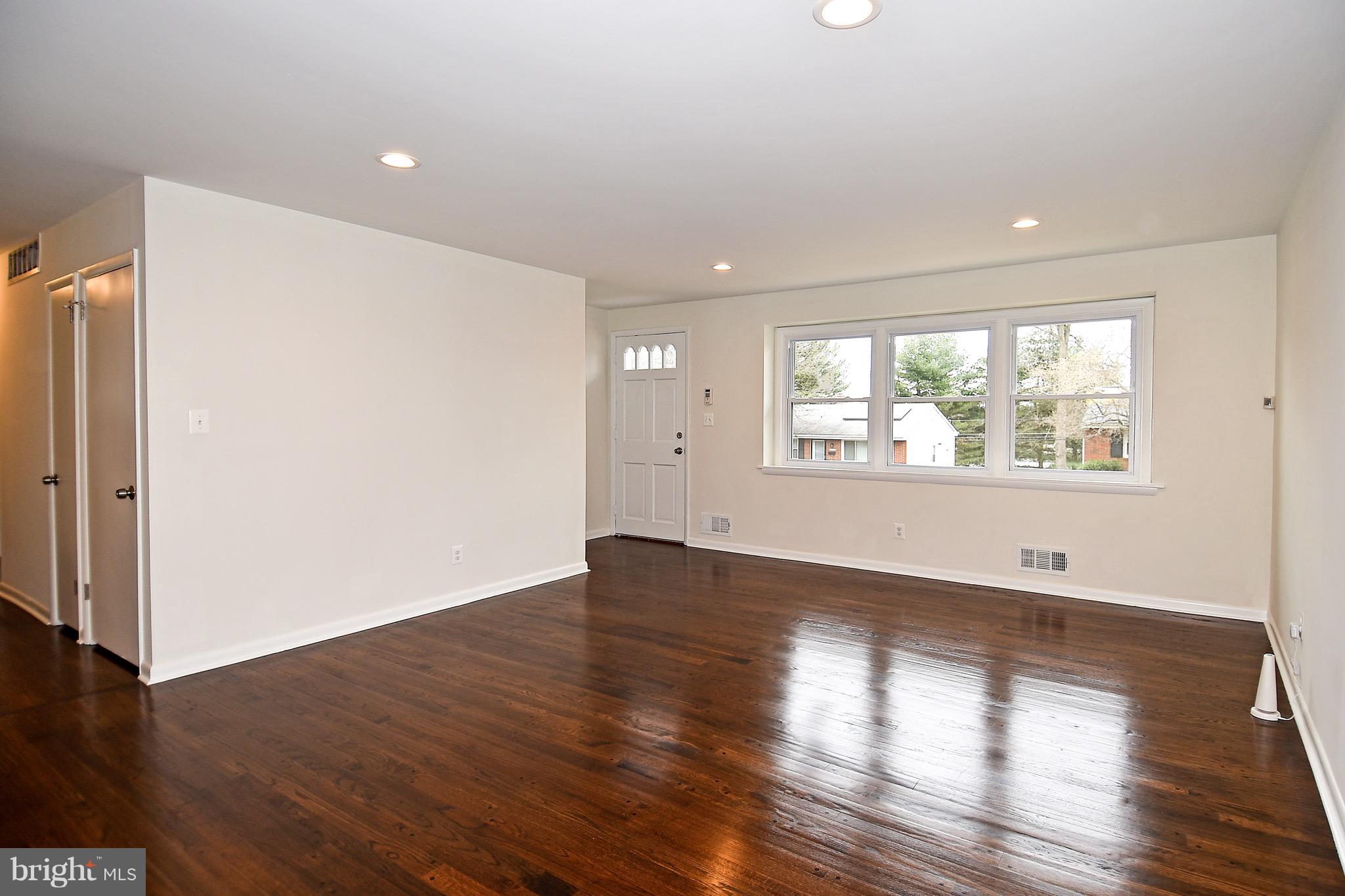 8609 Woodspring Road Randallstown, MD 21133 - Photo 5 of 43 an empty room with wooden floor and windows