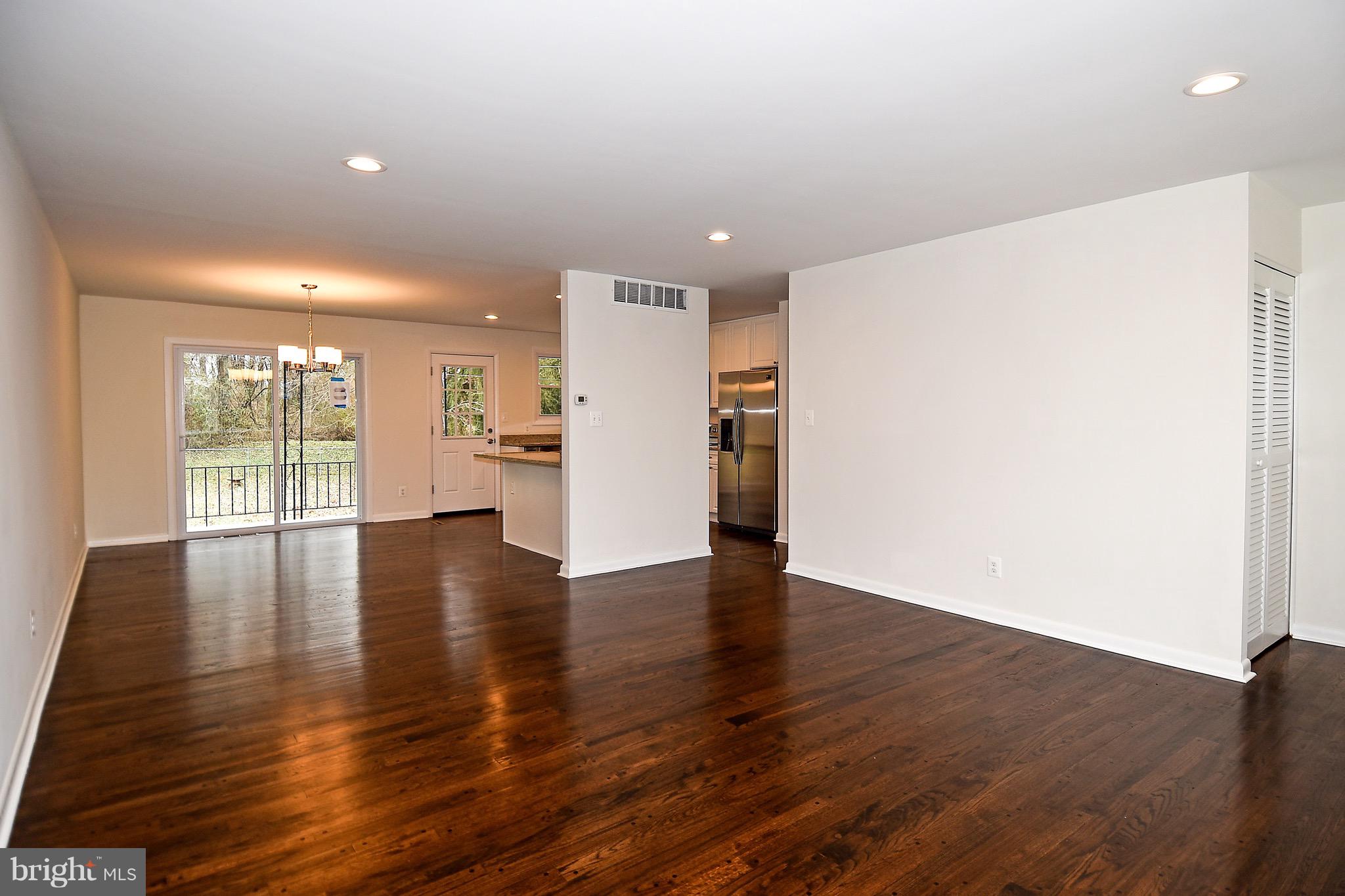 8609 Woodspring Road Randallstown, MD 21133 - Photo 6 of 43 a view of an empty room with wooden floor and a window