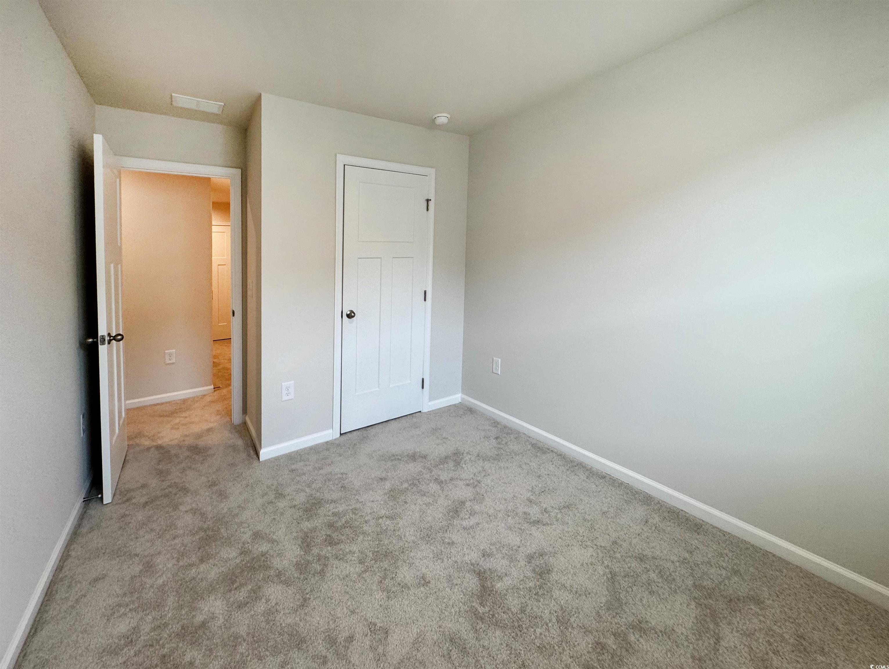157 B Villa Grande Street, Unit B Myrtle Beach, SC 29579 - Photo 19 of 28 Unfurnished bedroom featuring light colored carpet and a closet