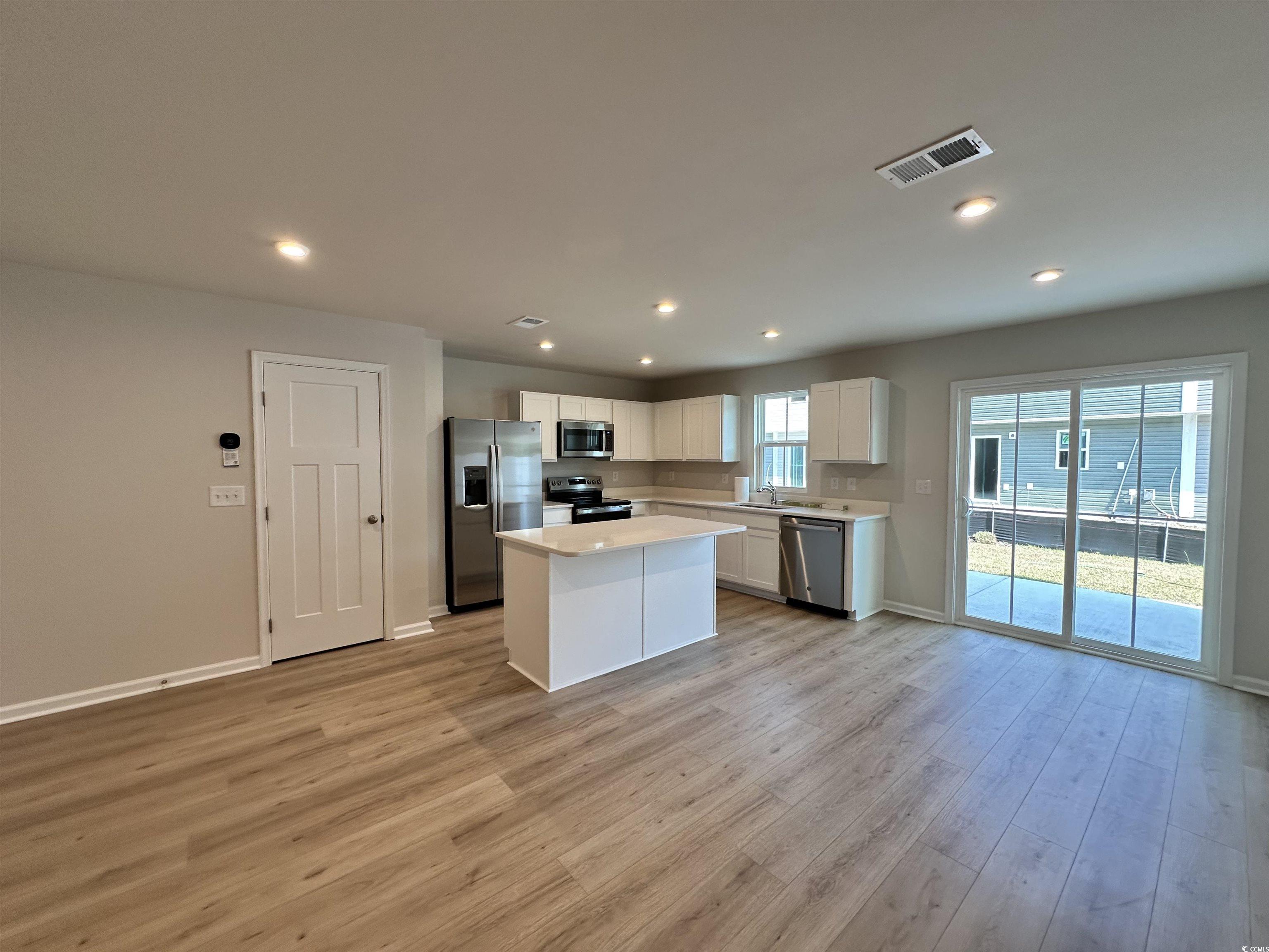 157 B Villa Grande Street, Unit B Myrtle Beach, SC 29579 - Photo 27 of 28 Kitchen with white cabinetry, appliances with stainless steel finishes, open floor plan, a center island, and recessed lighting