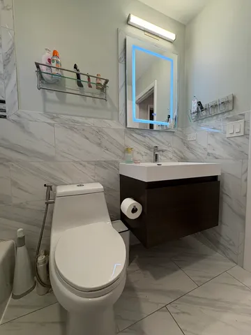 a bathroom with a toilet sink and mirror